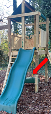 Blue slide on a wooden playground tower, with a red arrow pointing to the lower support beam.