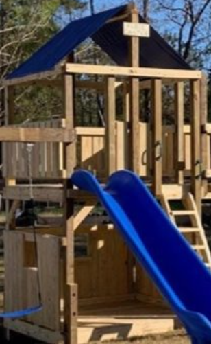 Wooden playground structure with blue slide and roof, outdoors in daylight