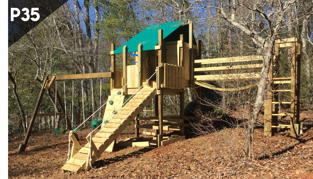 Wooden playground structure with teal roof, stairs, slides, and bridges in a wooded park.