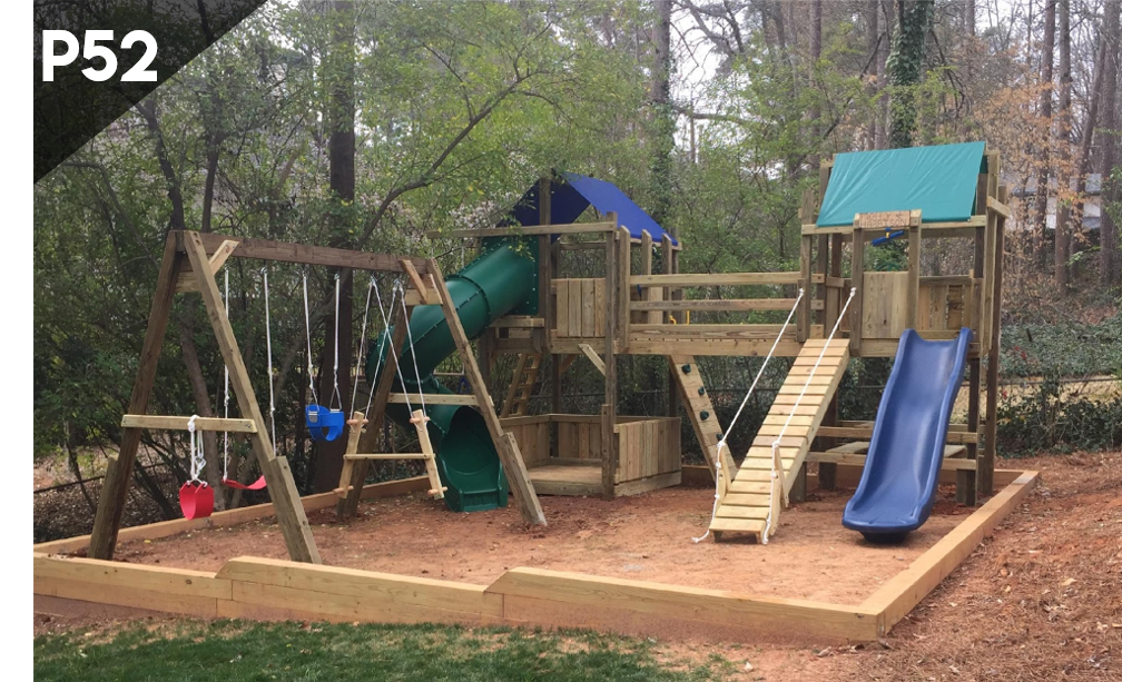 Wooden playground with slides, swings, and climbing structures in a wooded park
