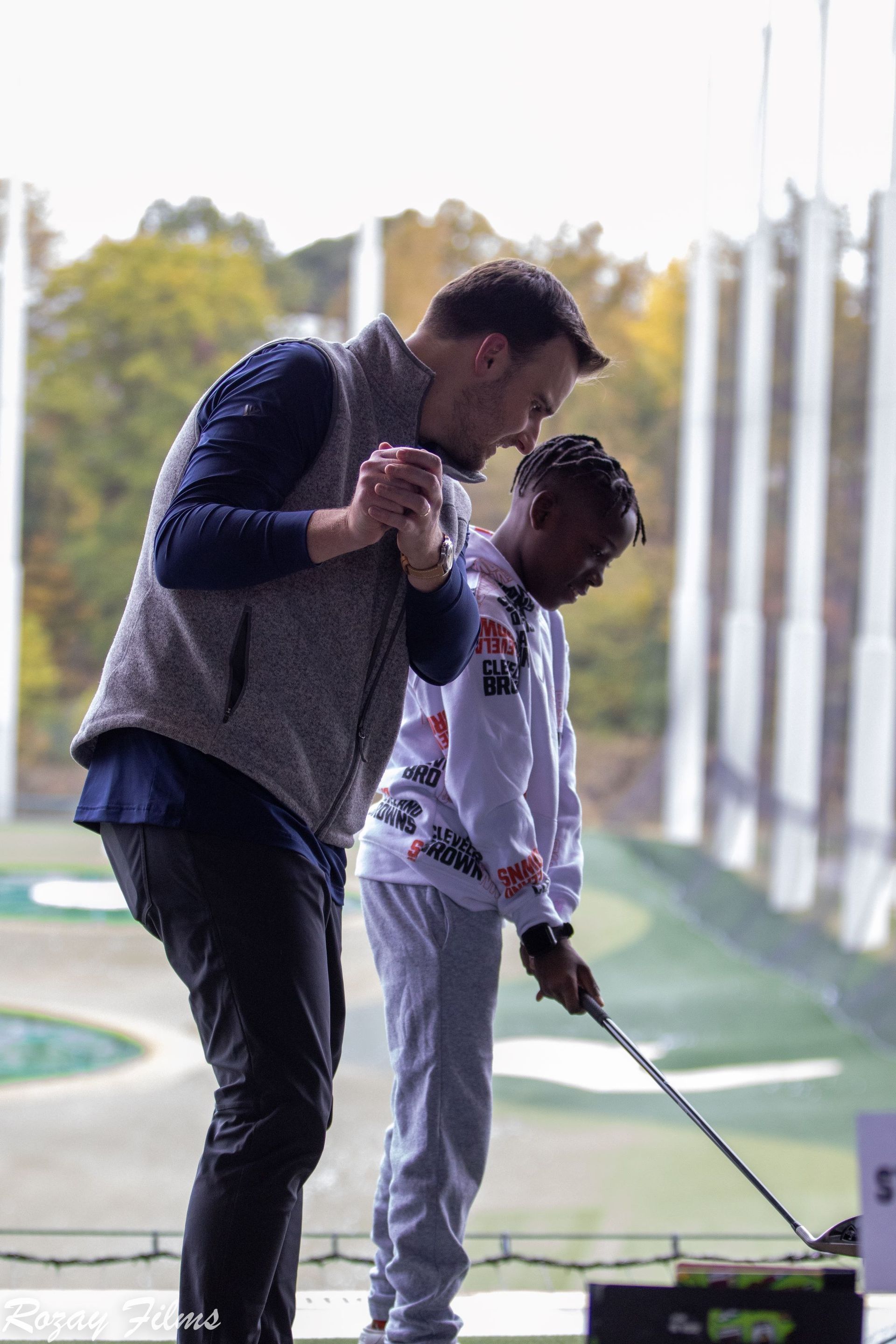 Big guiding a Little’s swing at a driving range
