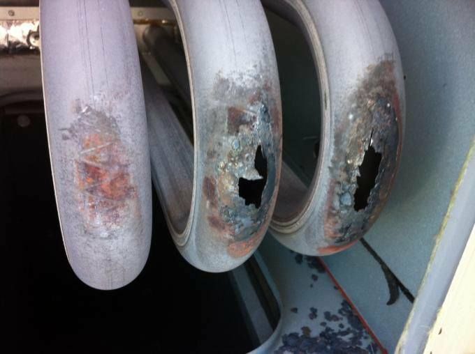A close up of a rusty pipe with a hole in it