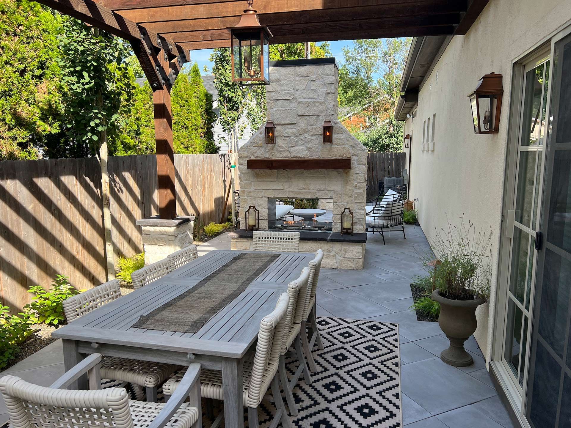 A patio with a table and chairs and a fireplace