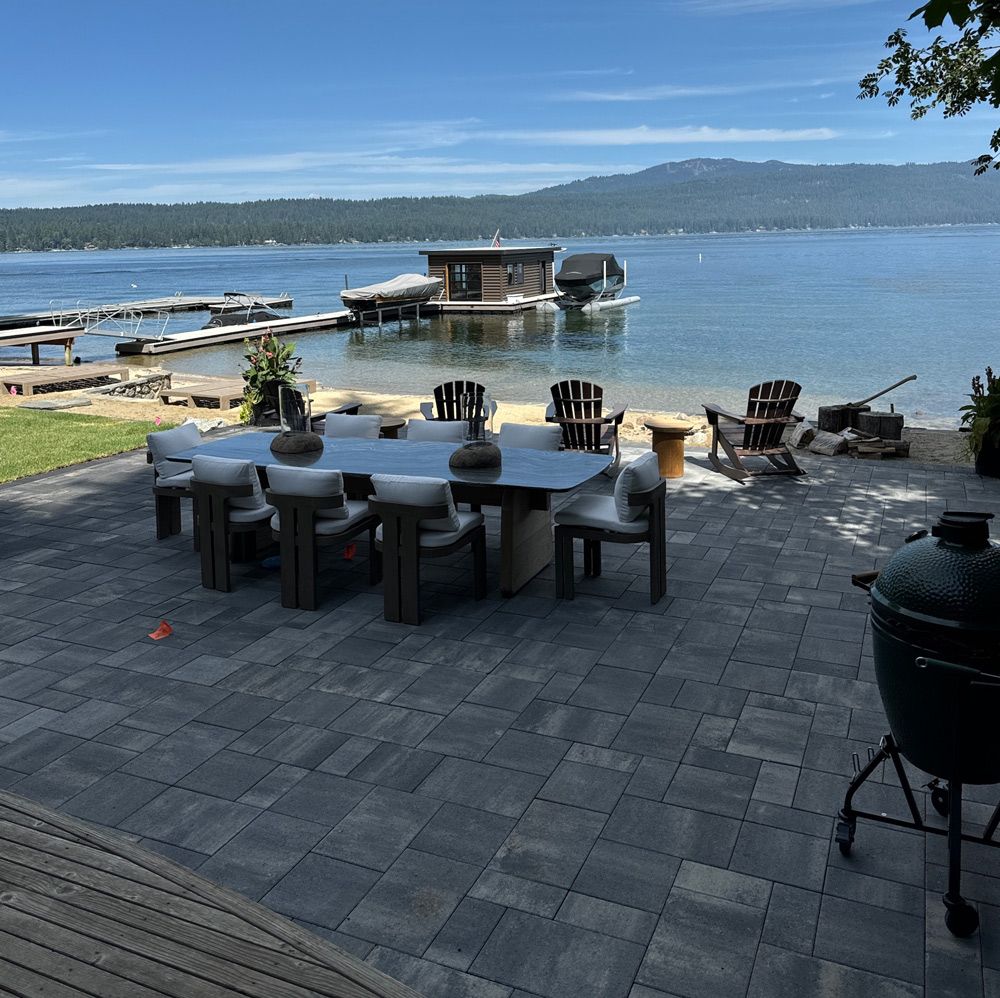 Three potted plants are sitting on the sidewalk in front of a house