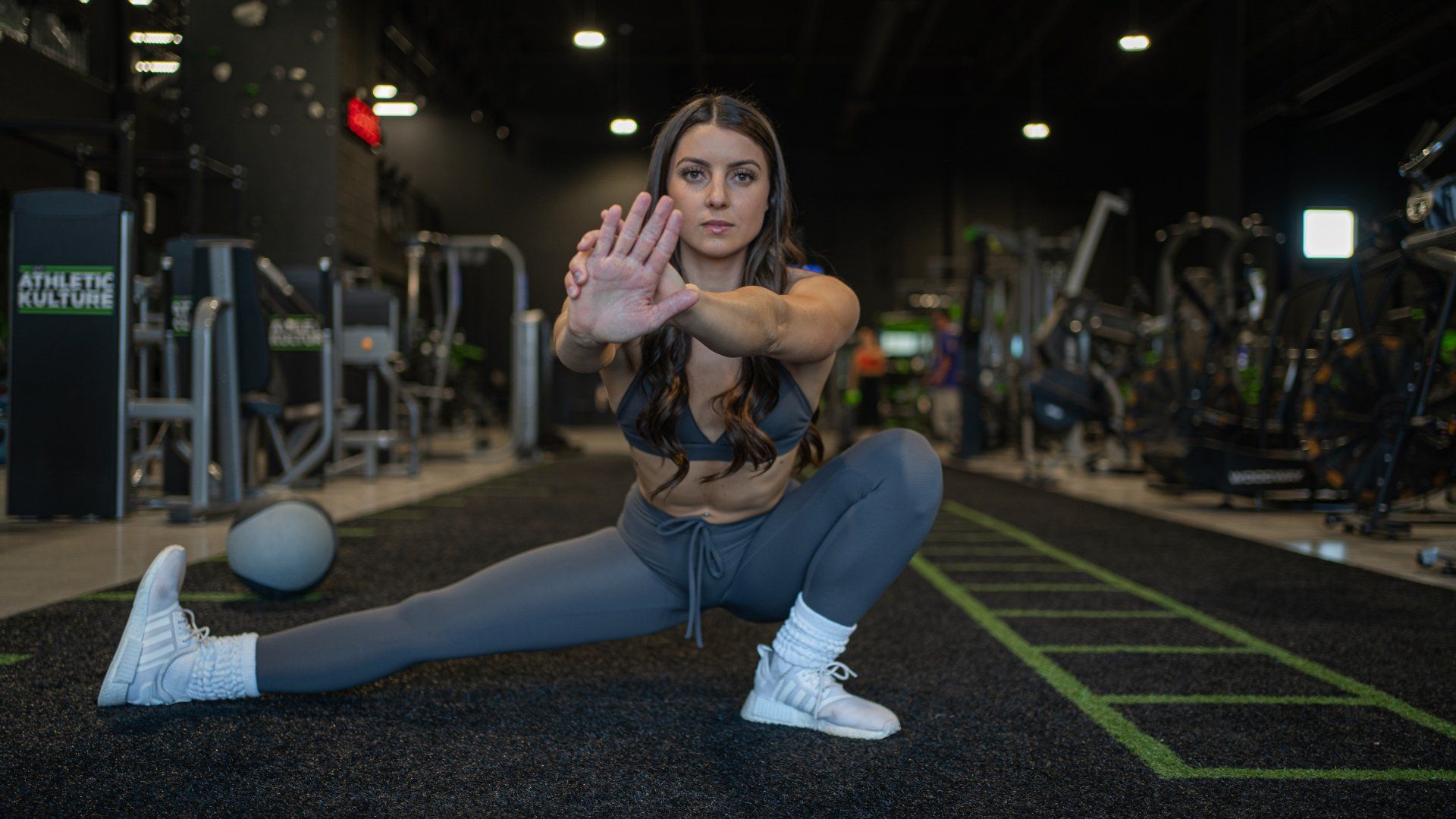 A woman is doing a split in a gym.