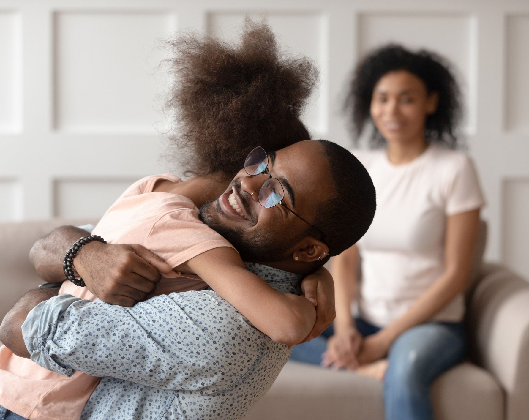 Father Hugging His Child And Mother Sitting
