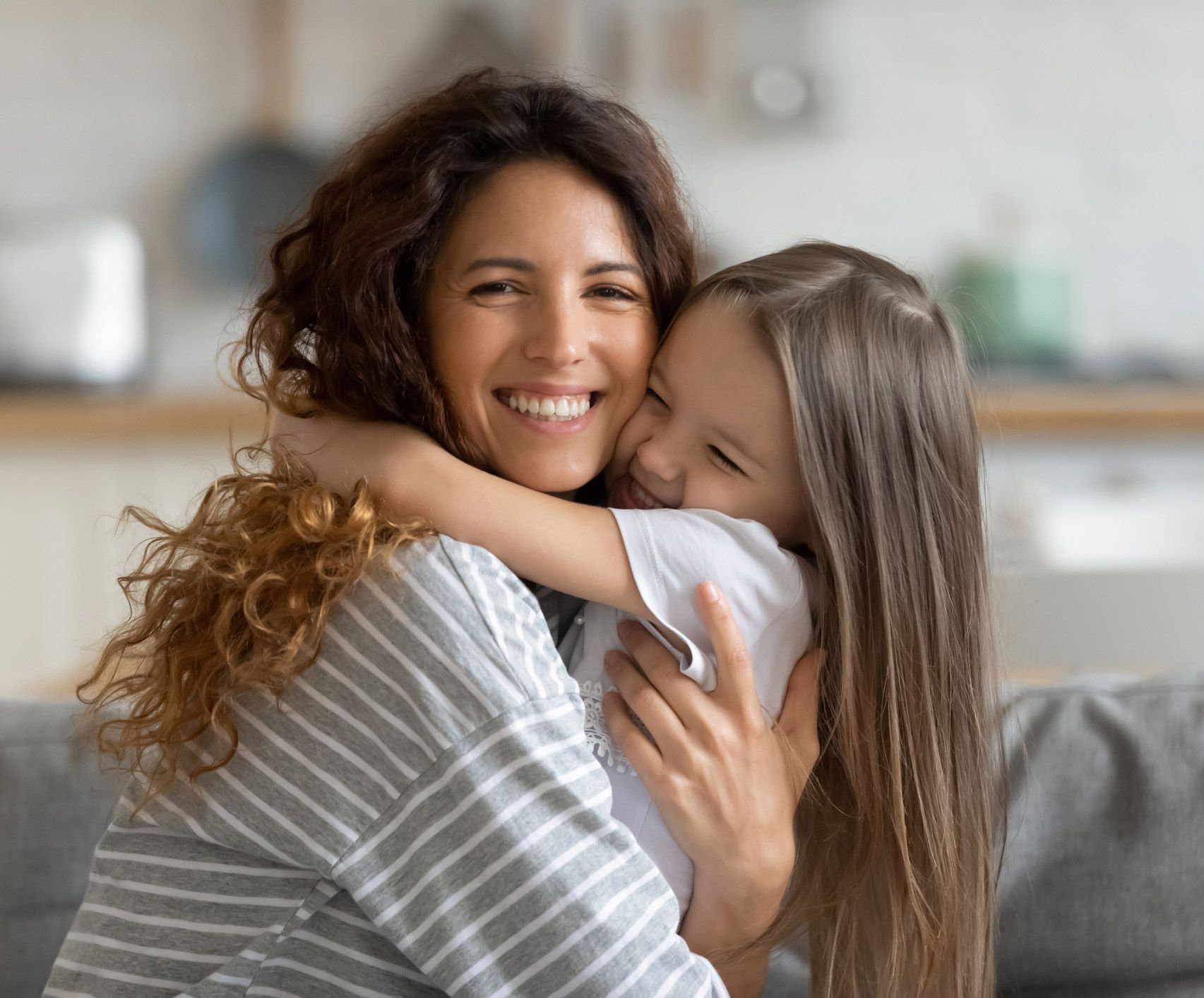 Mother And Daughter Hugging Warmly
