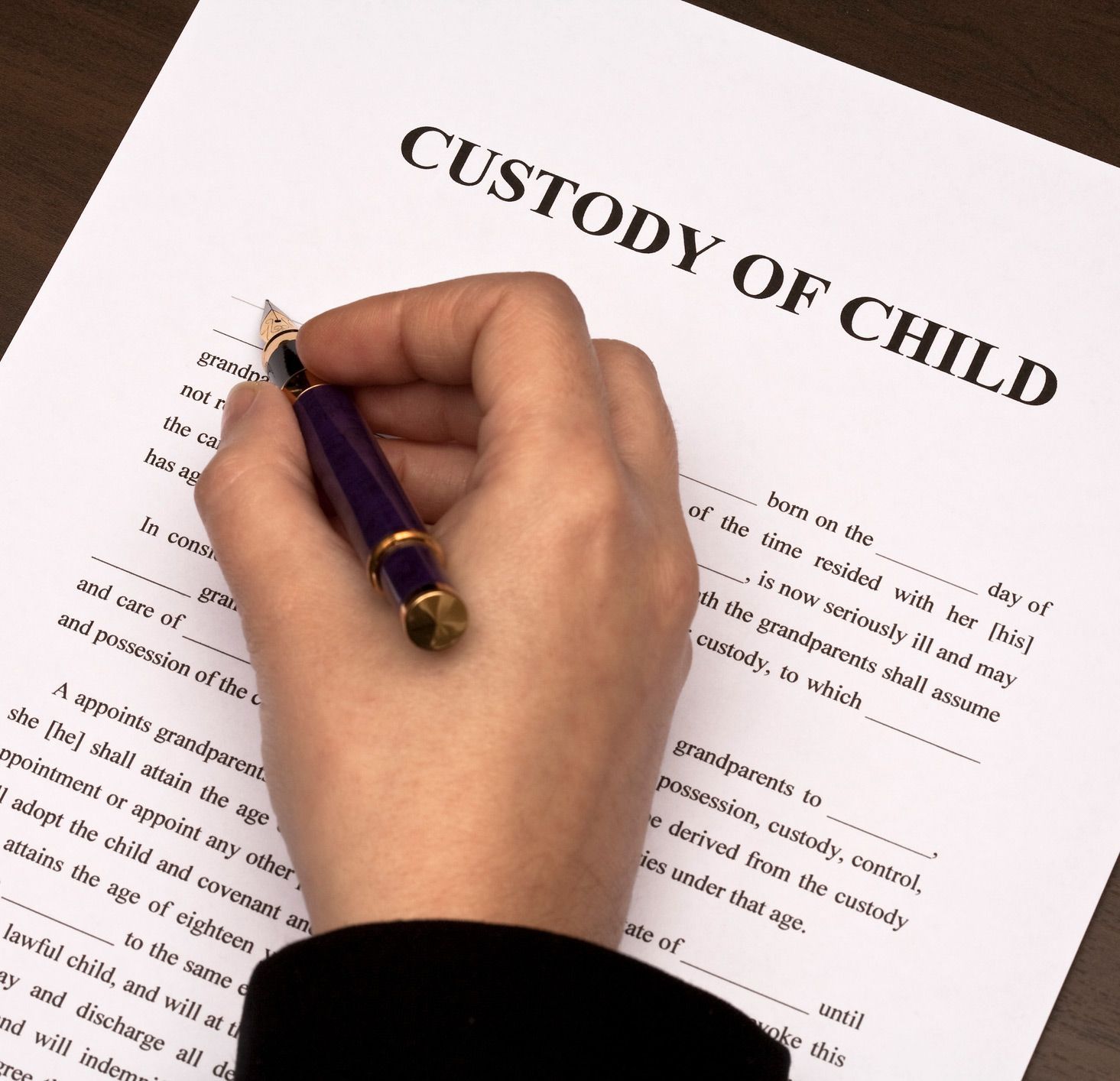 Hand Signing Child Custody Paper
