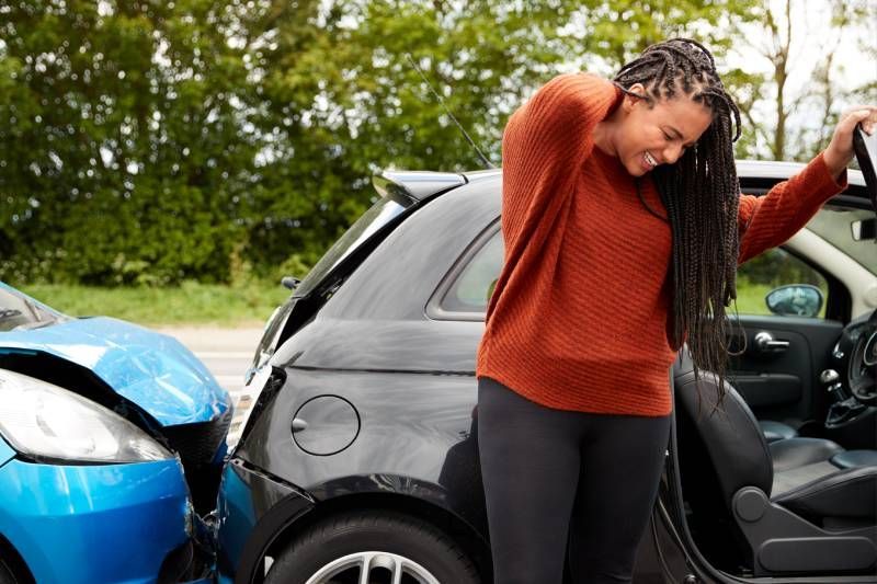 Personal Injury Law Book And Gavel — Fairlawn, OH — Susan Lax Law Office Woman Holding Sore Neck After Accident