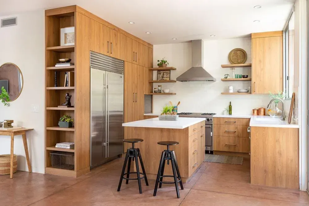 A kitchen with wooden cabinets , stainless steel appliances , and a large island.