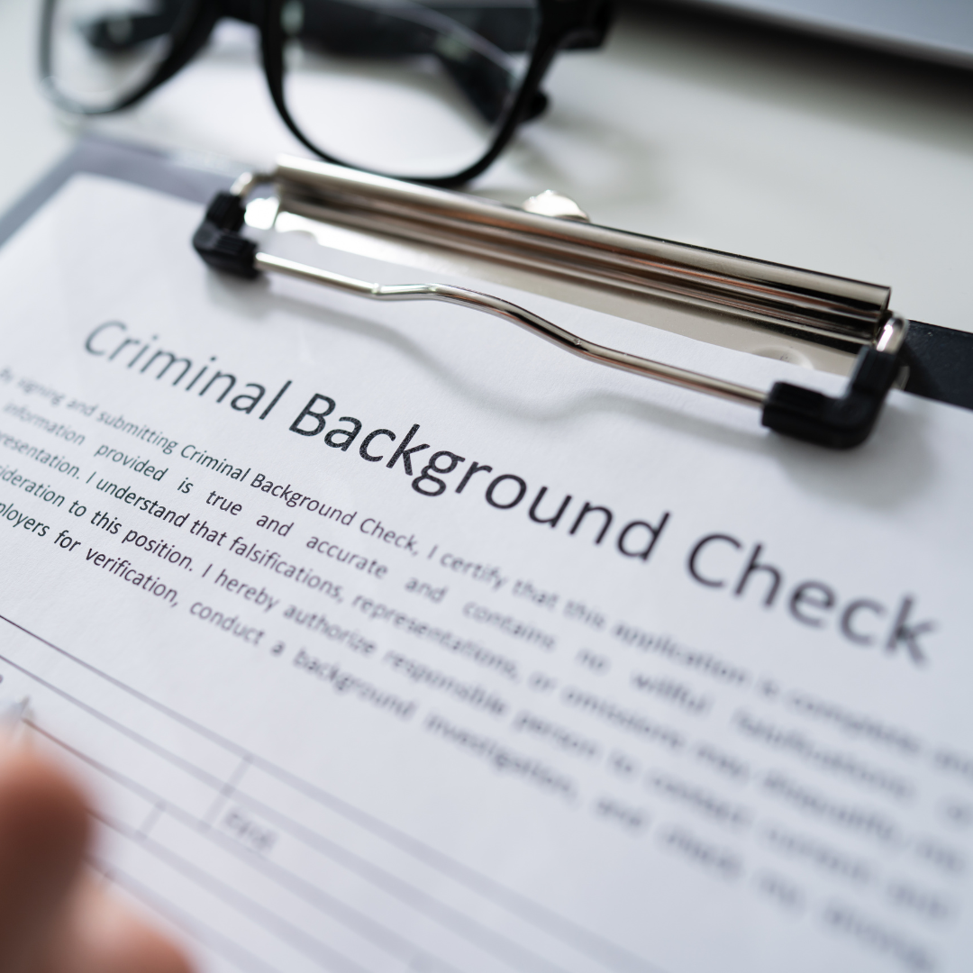 A clipboard with the words criminal background check on it