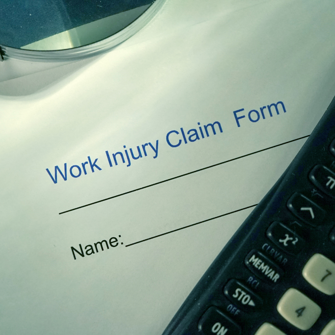 A work injury claim form next to a calculator