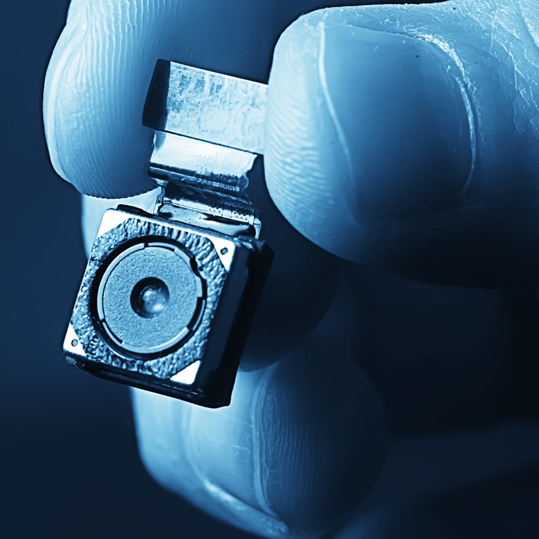 A person is holding a small camera in their hand