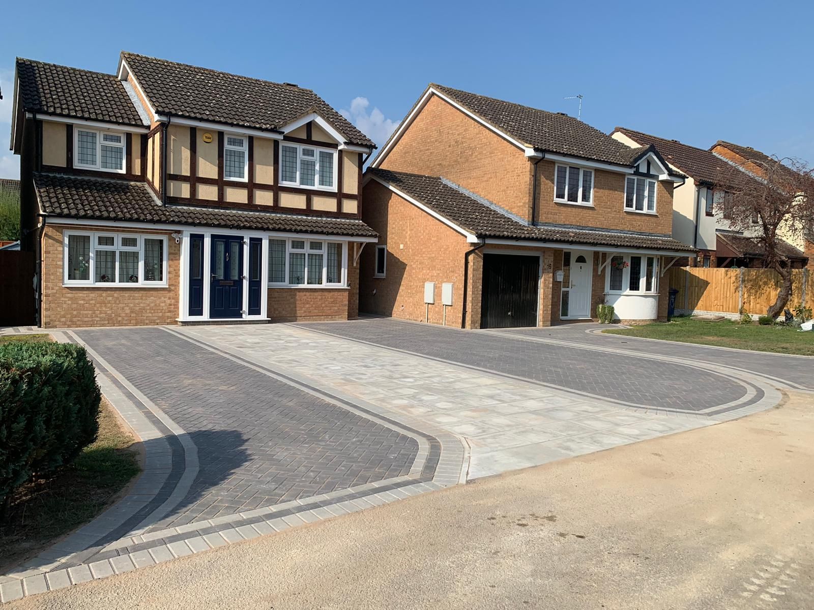 Suburban street with two modern brick houses and wide paved driveways