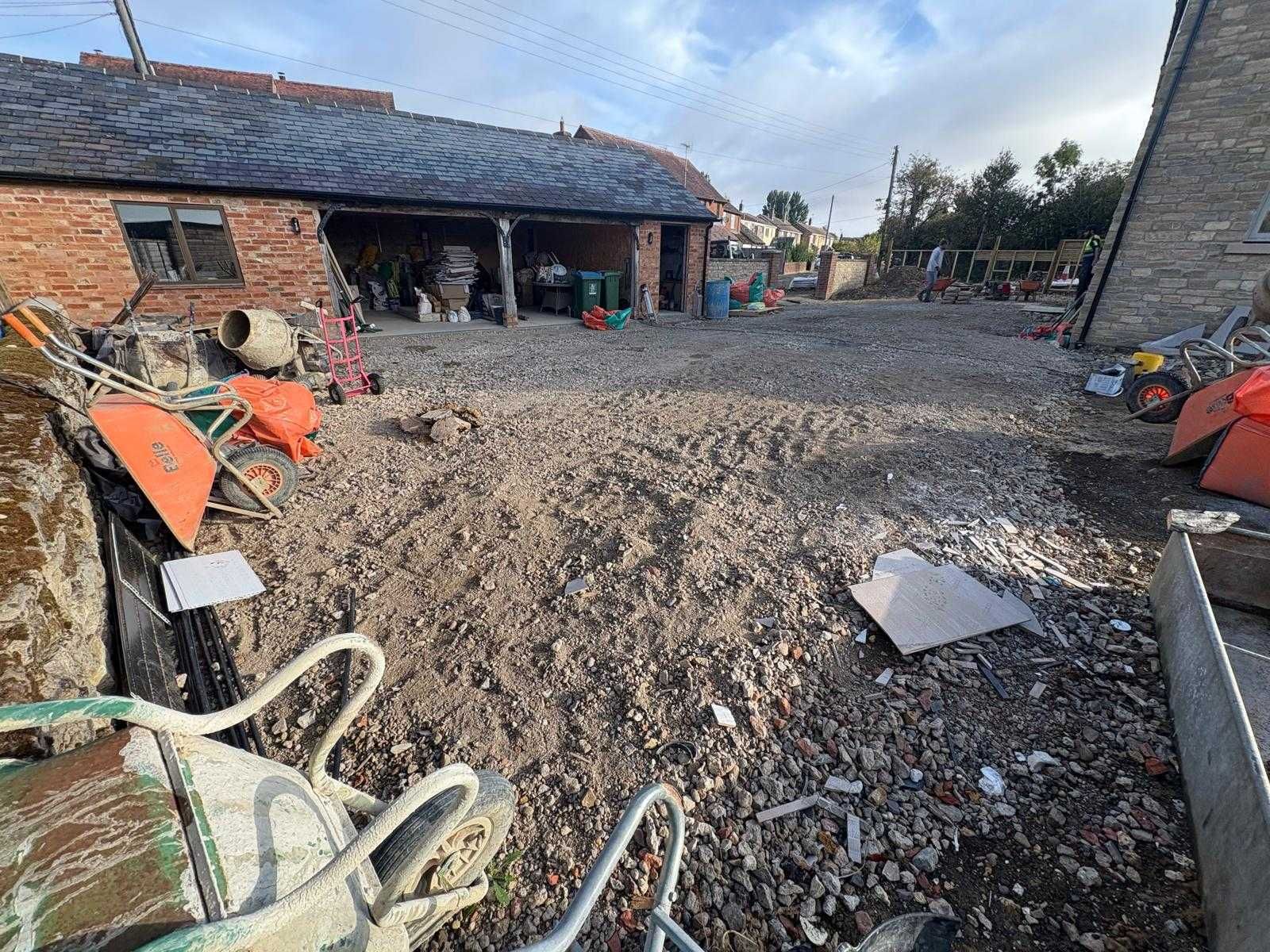 Flooded courtyard with muddy water, brick buildings, and scattered debris after heavy rain