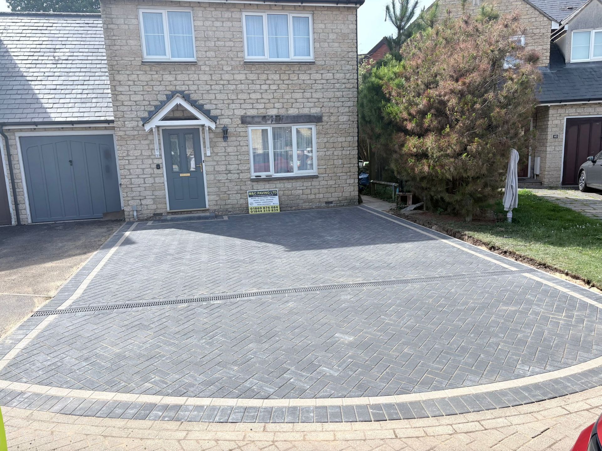 Modern two-story house with a tiled driveway and landscaped front yard