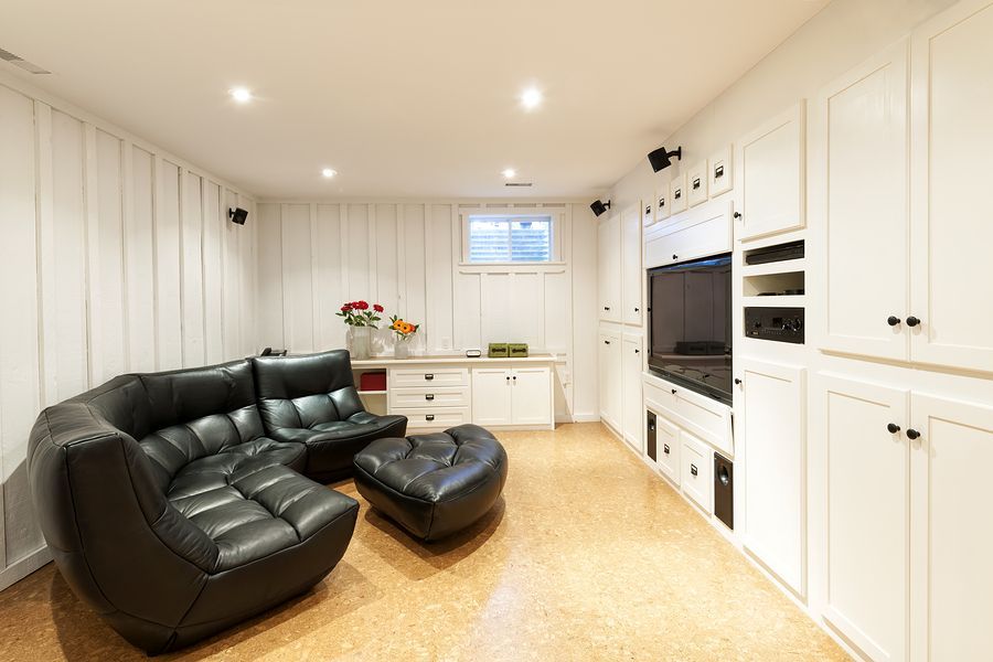 A living room with a black couch and ottoman