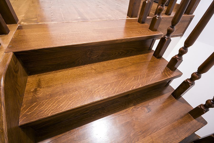 A close up of a wooden staircase with a wooden railing