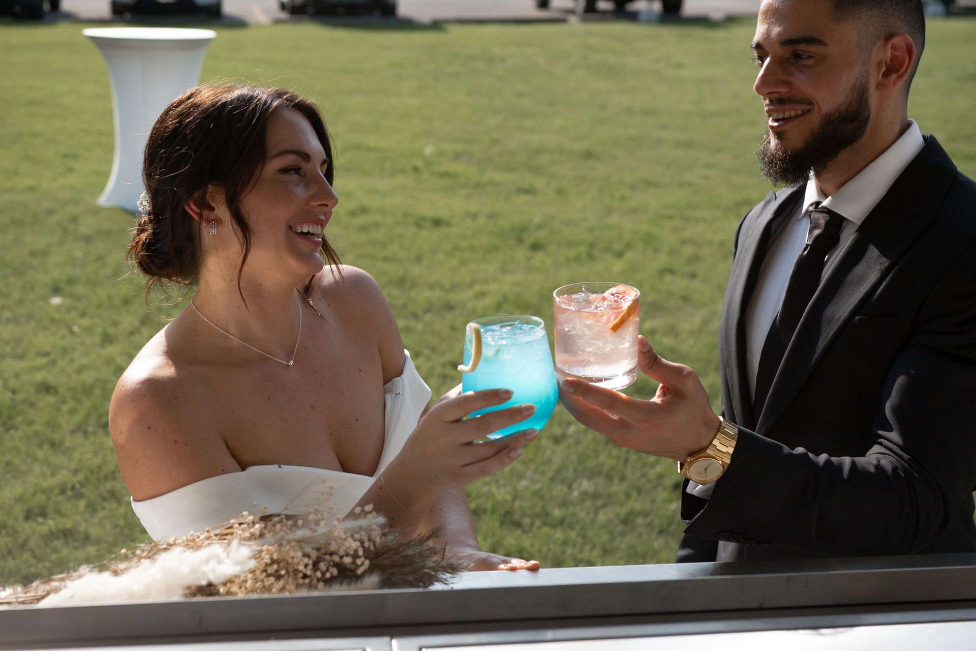 Couple enjoying colourful drinks outside The Cocktail Cart