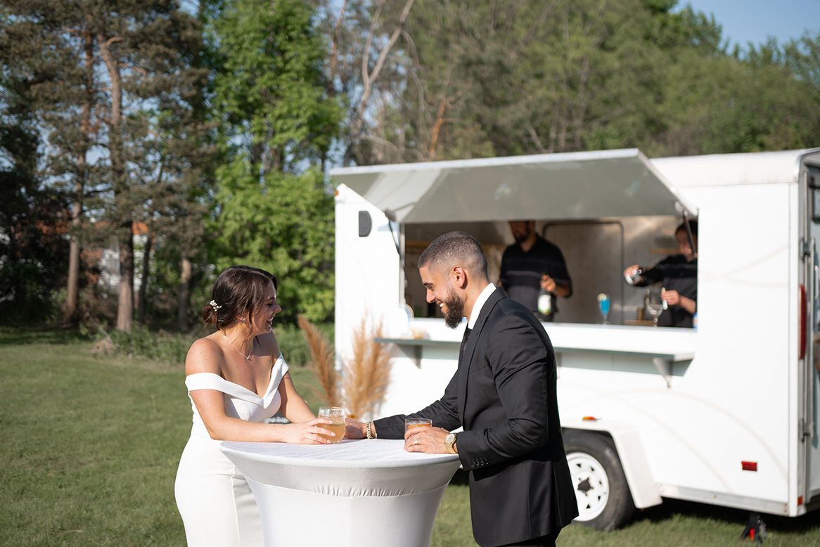 A newly-wed couple laughing outside The Cocktail Cart