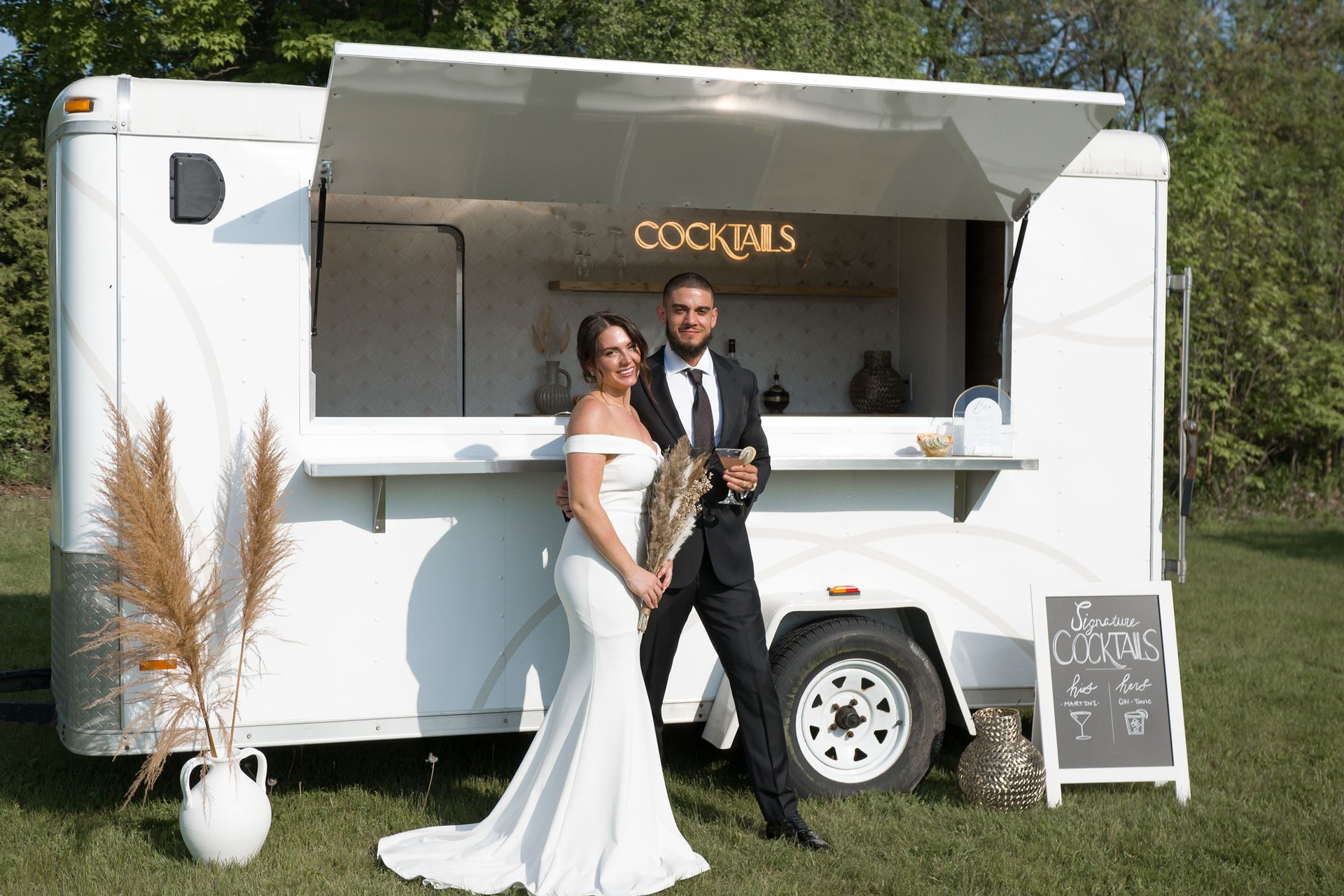 Married couple standing outside The Cocktail Cart smiling
