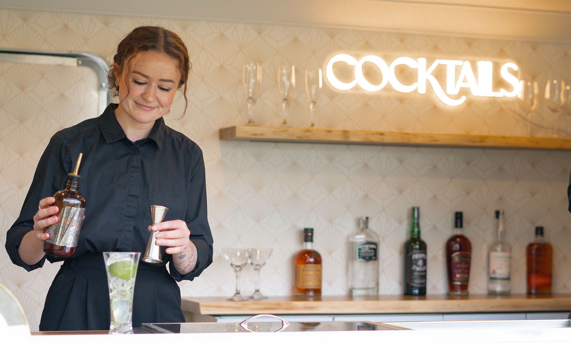 A bartender mixing a drink in The Cocktail Cart