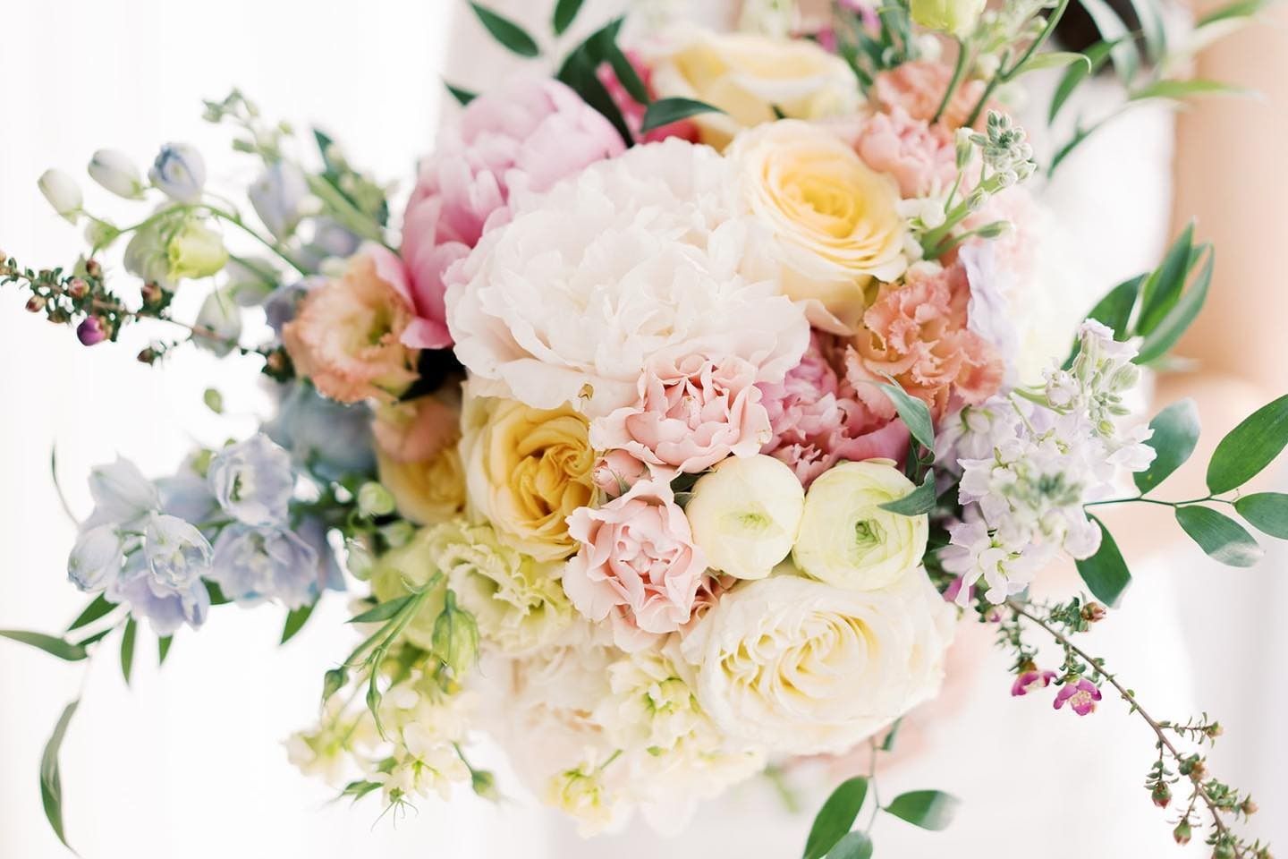 Pastel floral bouquet with pink, cream, yellow, and lavender flowers and green foliage