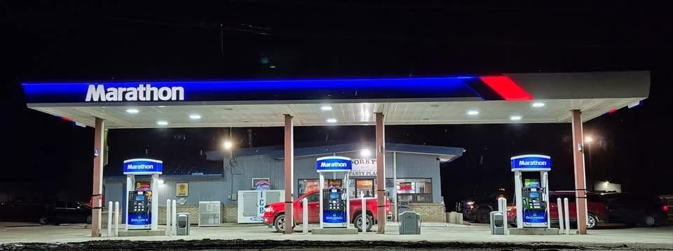 Marathon gas station at night with illuminated pumps and store canopy