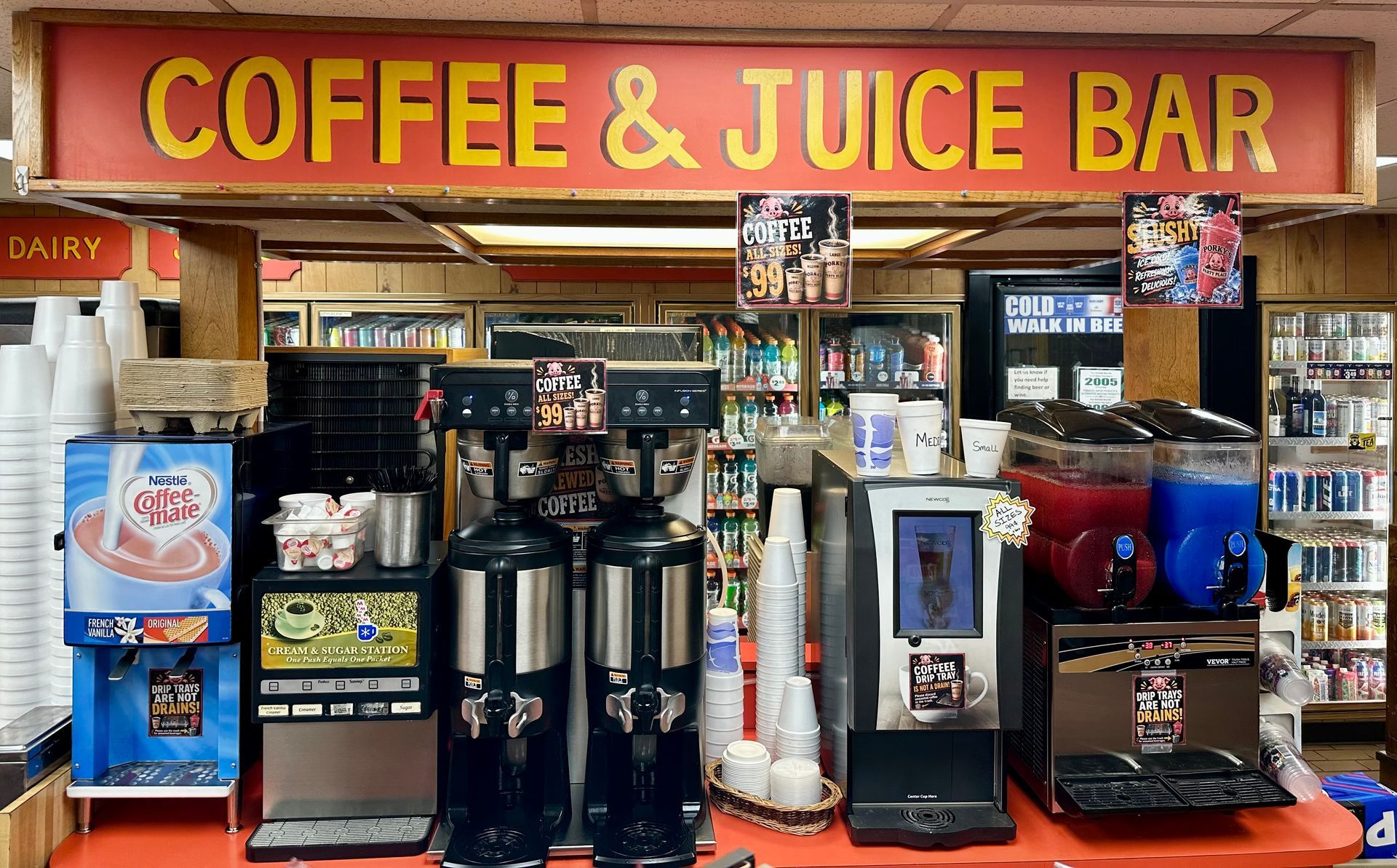 Coffee and juice bar counter with drink machines, cups, and colorful beverage dispensers
