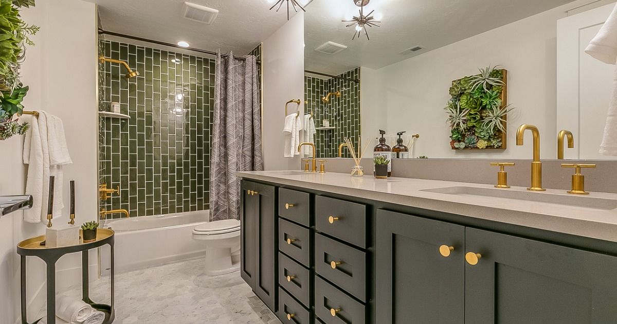 A bathroom with two sinks , a tub , and a mirror.