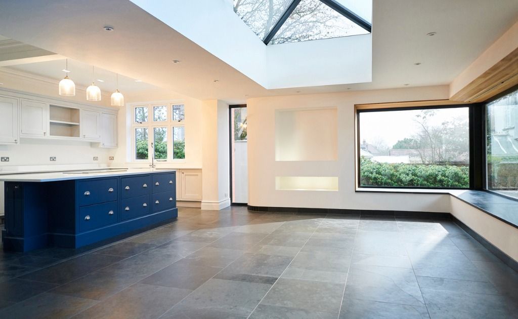 An empty kitchen with a blue island and a large window