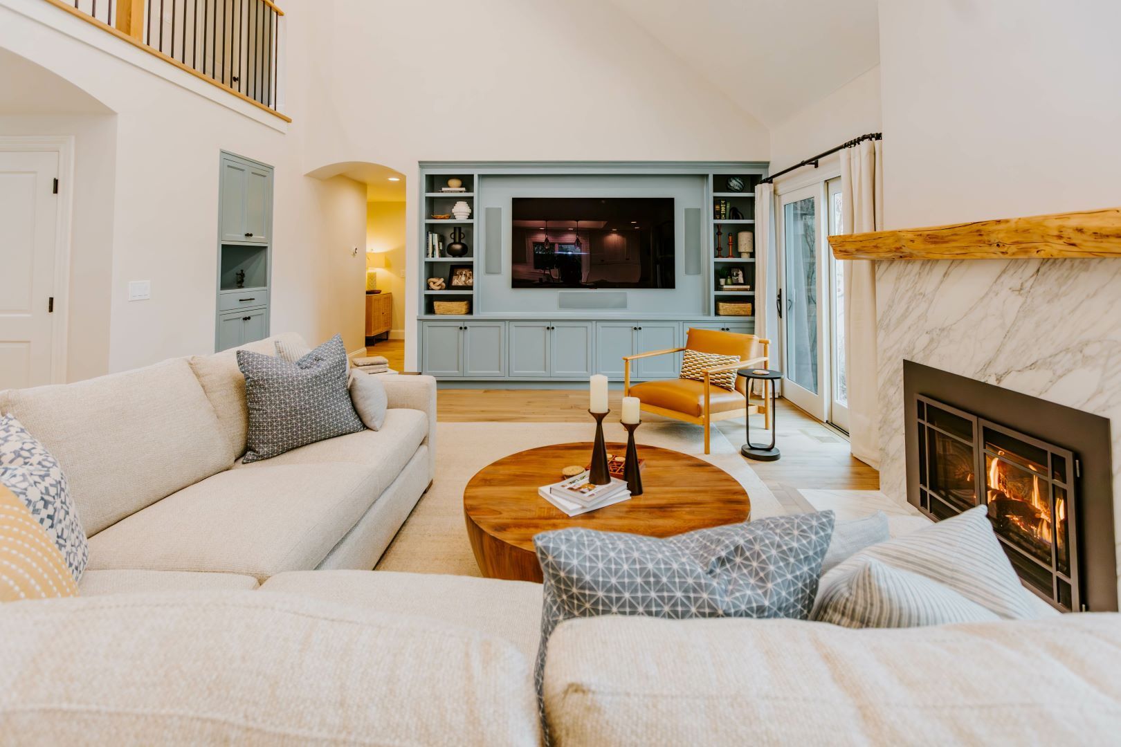 Living room with a fireplace, TV, and sectional sofa, with a neutral color palette.