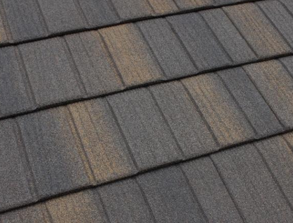 Close-up of gray asphalt roof shingles with a few weathered tan patches