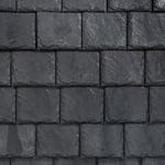 Dark gray cobblestone pavement with rectangular stone blocks and narrow mortar lines