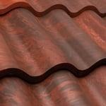 Close-up of red corrugated metal roof tiles with wavy ridges and weathered texture