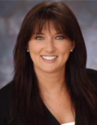 A woman with long brown hair is smiling for the camera