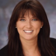 A woman with long brown hair is smiling for the camera