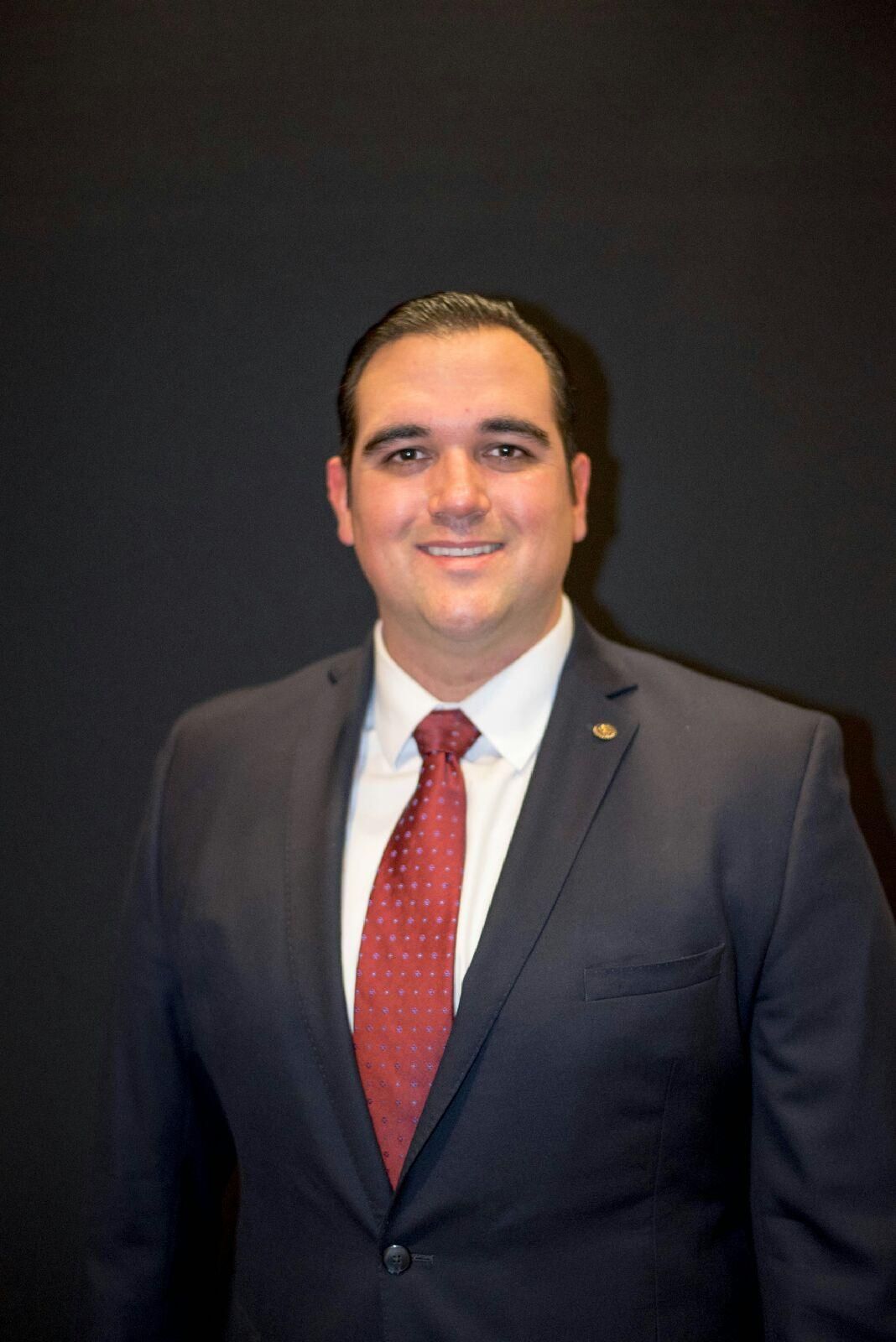 A man in a suit and tie is smiling for the camera.