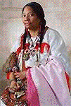 A woman in a native american dress is sitting on a table.