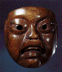 A close up of a wooden mask on a blue background.