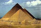 Two pyramids are sitting next to each other in the desert.