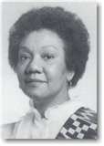 A black and white photo of a woman with curly hair.