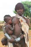 A woman is holding a baby in her arms.