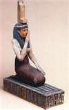 A statue of a woman kneeling down with her hands folded.