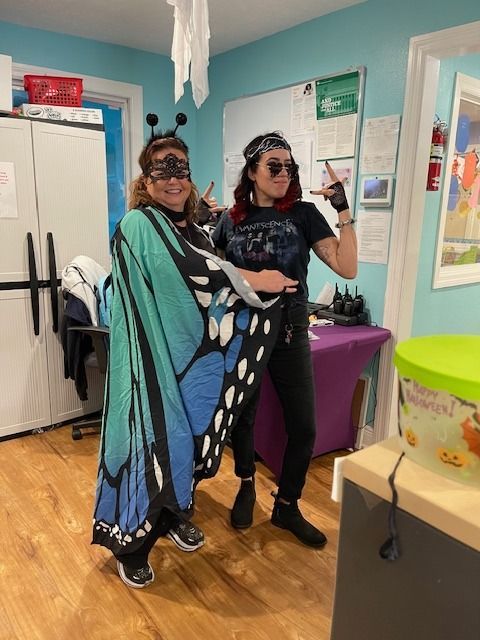 Two women dressed in butterfly costumes are standing next to each other