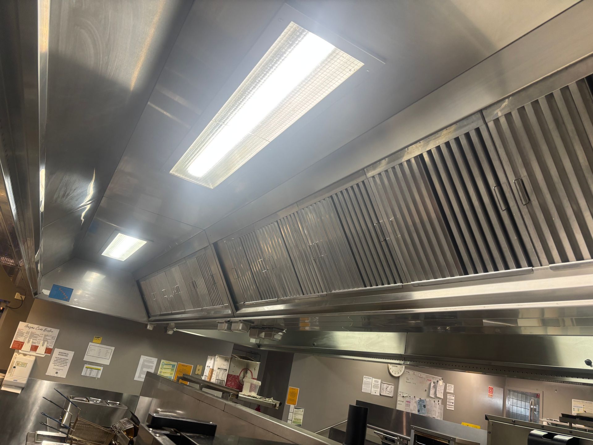 A large commercial kitchen with lots of stainless steel appliances — DM & MM Services Pty Ltd in Ayr, QLD