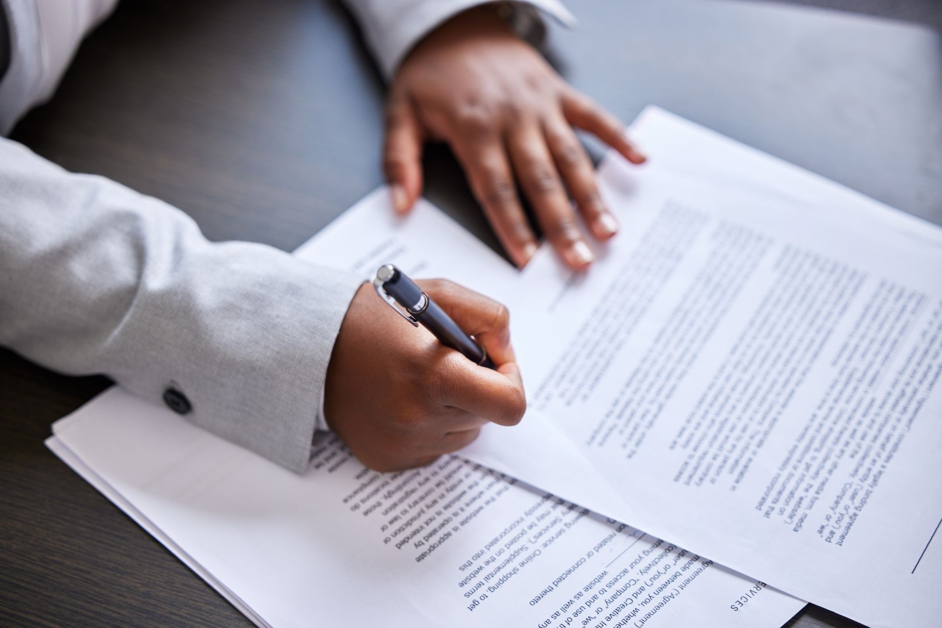 A person is writing on a piece of paper with a pen.