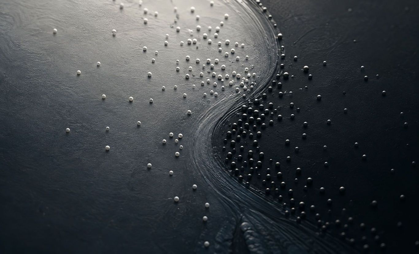 Abstract aerial view of dark water with ripples and scattered white foam or ice dots