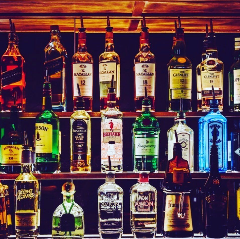 Bottles of alcohol on a shelf including a bottle of bacardi