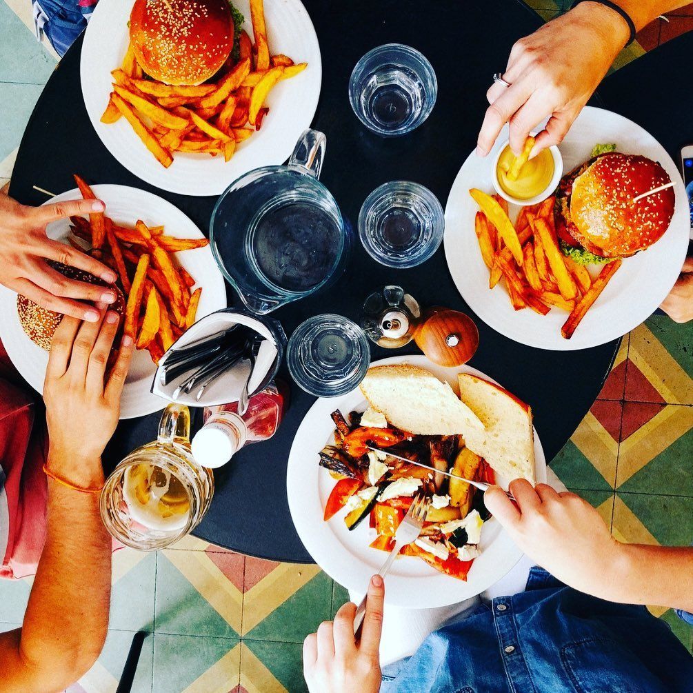A group of people are sitting around a table eating food